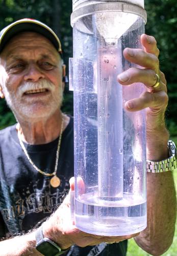 Jim Hilt of Bow holds his rain gauge that overflowed into the outer container after last Thursday’s 2.11 inches of rain. The inner tube holds an inch of water and then overflows into the outer portion.