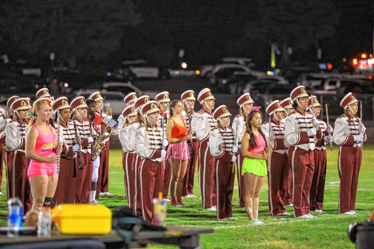 (Left to right) Addison Cain, Charlotte Lynn and Millai Colfry stand amongst the rest of the band in their cheer attire.