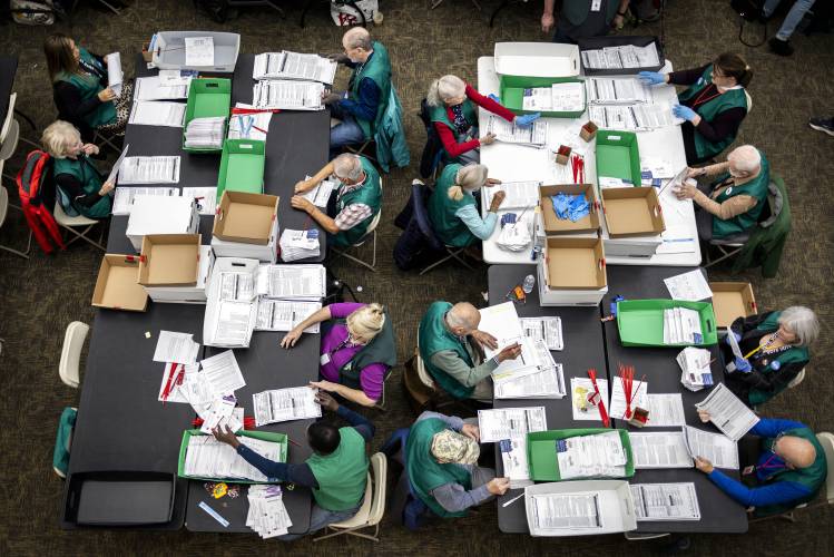 Election workers review ballots at the Denver Elections Division in Denver on Election Day on Tuesday.