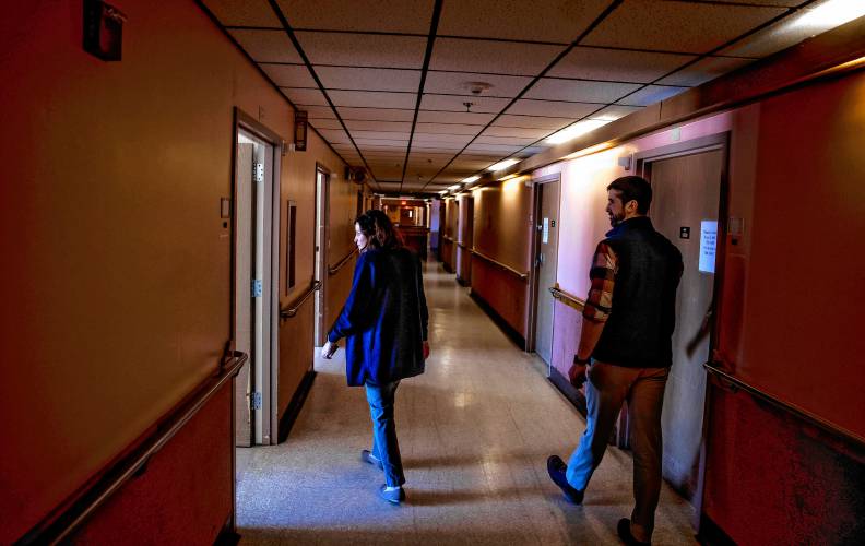 Merrimack County Nursing Home administrator Heather Moquin walks the darkened hallways of the old dementia care floors of the McLeod Building with assistant administrator Ross Johnson on  March 3.  The floor was last used in 2008.