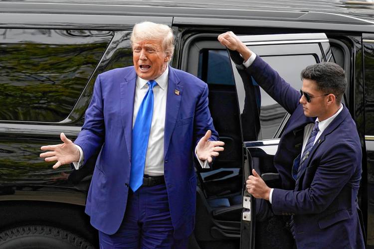Donald Trump gestures to supporters as he arrives to sign papers to be on the 2024 Republican presidential primary ballot at the New Hampshire State House on Monday.