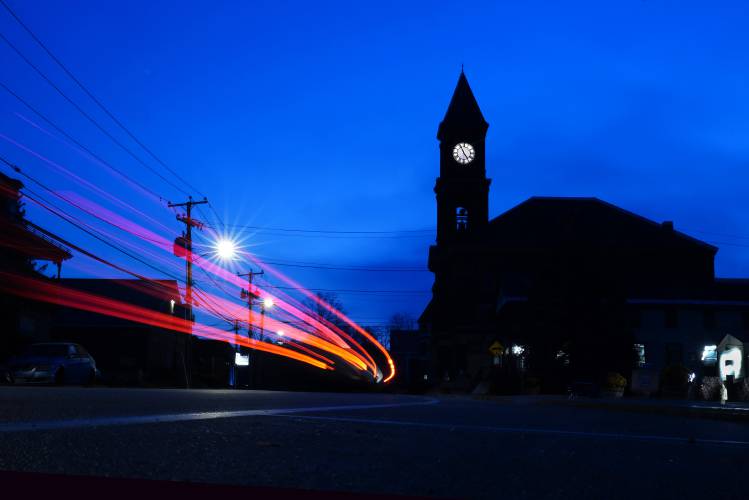 Pre-dawn traffic travels by Town Hall, Thursday, Nov. 16, 2023, in Hinsdale, N.H. The small town received a generous gift when a longtime resident passed away in June. (AP Photo/Robert F. Bukaty)