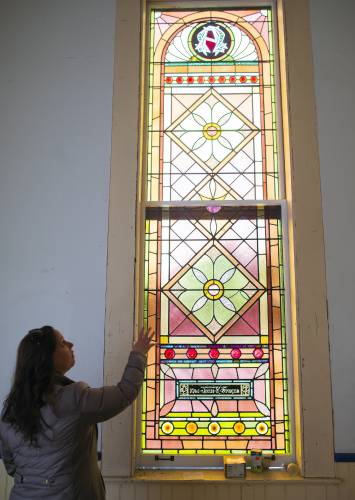 Meadow Wysocki of the Epsom Old Meeting House Revitalization Committee looks up at one of the stained glass windows that have been restored on Wednesday, January 12, 2022.