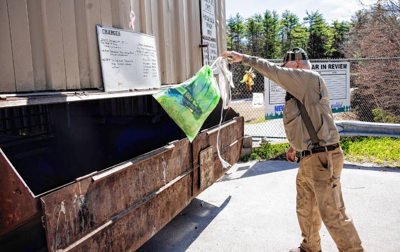 Brad Watson, a resident of Hopkinton for 50 years, empties his green bag for household items along with his agricultural waste items at the Hopkinton Transfer Station on Wednesday morning. Watson is not a fan of the green bags.