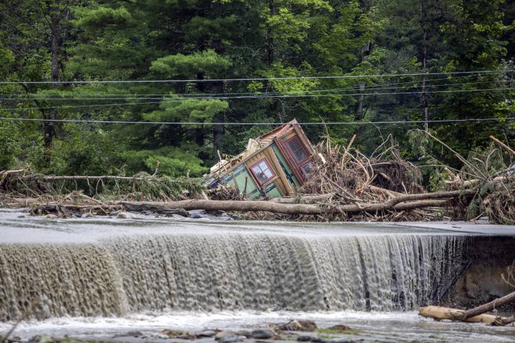 A damaged house sits amid flood debris in Lyndon, Vt., Tuesday, July 30, 2024. (AP Photo/Dmitry Belyakov)