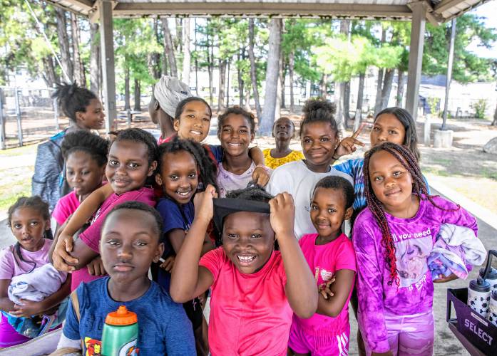 Children in the Project STORY program sit under a canopy before heading out to go swimming at Keach Park on Thursday, August 1.