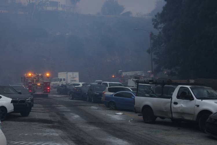 Vehicles are left stranded off the side of the road after residents tried to flee from the Palisades Fire in the Pacific Palisades neighborhood of Los Angeles, Tuesday, Jan. 7, 2025. (AP Photo/Etienne Laurent)