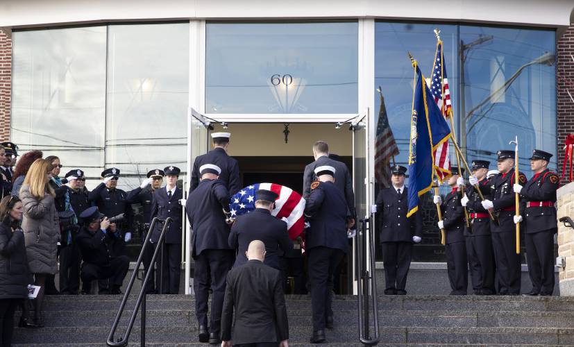 Firefighters from around the state of New Hampshire salute as the casket of Concord firefighter Christopher “CJ” is carried into Christ the King Parish in Concord on Thursday, March 13, 2025. 
