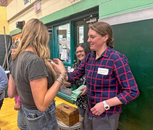 Sabrina Dunlap, select board chair helps out with the ballot voting at the Hopkinton School District annual meeting on Saturday.