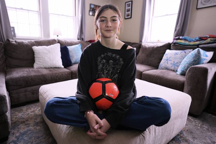 FILE - Parker Tirrell, a transgender athlete who plays on her high school's girls soccer team, poses in the living room of her family home, March 7, 2025, in Plymouth, N.H. (AP Photo/Charles Krupa, File)
