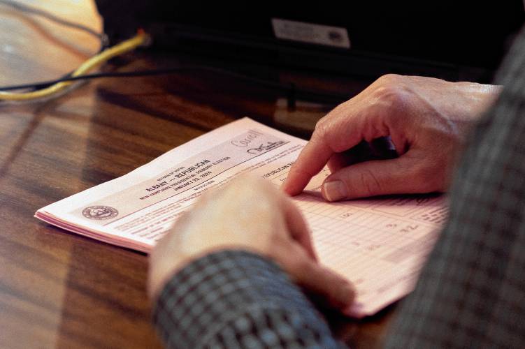 A New Hampshire Secretary of State official Dan Cloutier checks the ballots matching them with the electronic tallies in the Executive Council Chambers at the State House on the morning after the primary on Wednesday, January 24, 2024.