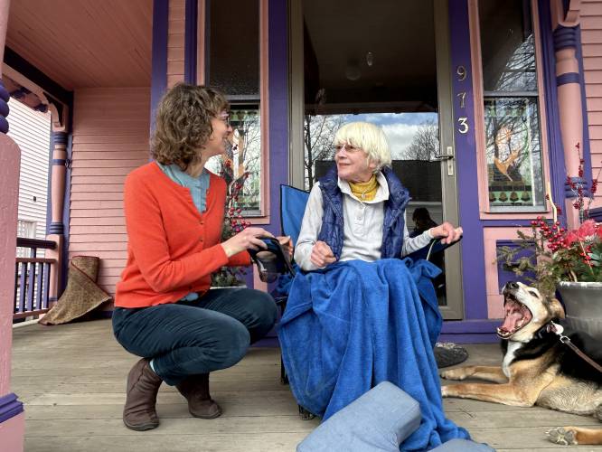 Barbara Filion and her daughter Marsha Filion enjoy a quiet morning on their front porch in Portsmouth with their neighbor's dog Buddy.