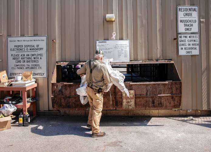 Brad Watson, a resident of Hopkinton for 50 years, empties his green bag for household items along with his agricultural waste items at the Hopkinton Transfer Station on Wednesday morning. Watson is not a fan of the green bags.