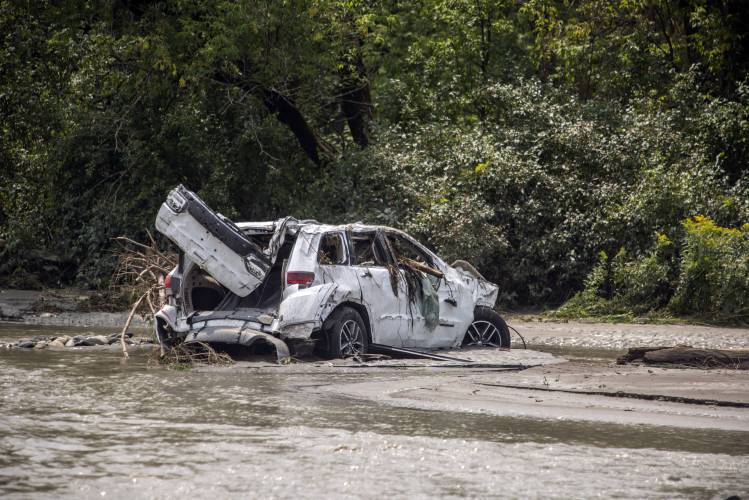 A damaged car sits amid flood debris in Lyndon, Vt., Tuesday, July 30, 2024. (AP Photo/Dmitry Belyakov)