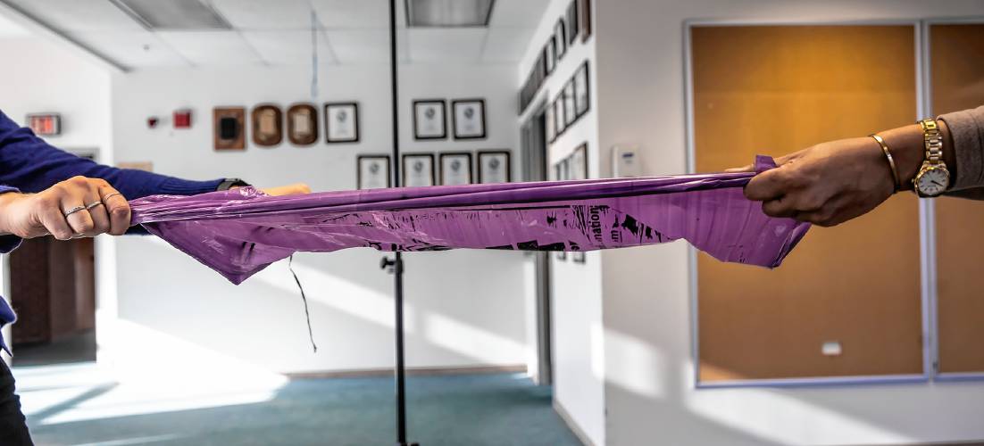 The purple trash bag did stretch and tear when it was pulled apart.