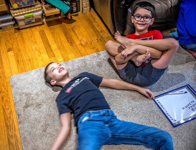 Kristen LeGeyt’s living room is a busy place but her sons, Ryan (left) and Greyson get to play as well as work on their studies.