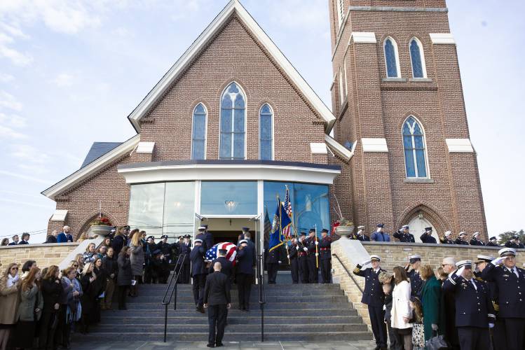 Firefighters from around the state of New Hampshire salute as the casket of Concord firefighter Christopher “CJ” is carried into Christ the King Parish in Concord on Thursday, March 13, 2025. 