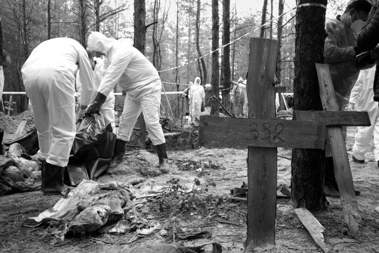 Volunteers work to remove bodies from a mass grave in Izium, Ukraine shortly after the city was liberated.