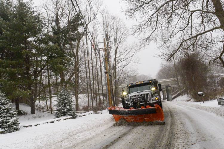 A snowplow removes the snow on Maple Street in Brattleboro, Vt., while the snow falls on Saturday, March 23, 2024. New England is battling a mix of wind, rain, sleet and heavy snow across the region Saturday with more than a foot of snow expected in ski county, but mostly rain, wind and possible flooding in southern areas and along the coast. (Kristopher Radder /The Brattleboro Reformer via AP)