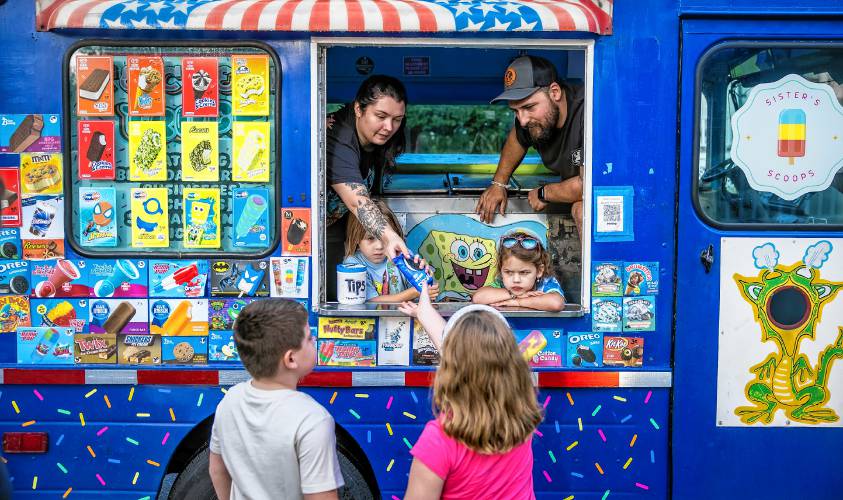 Maddy and Adam Gelinas serve up ice cream from their van in the neighborhood near where they live in Allenstown on Thursday evening, August 22, 2024. Their girls, Avery (left), and Maisie were there to help as well. 