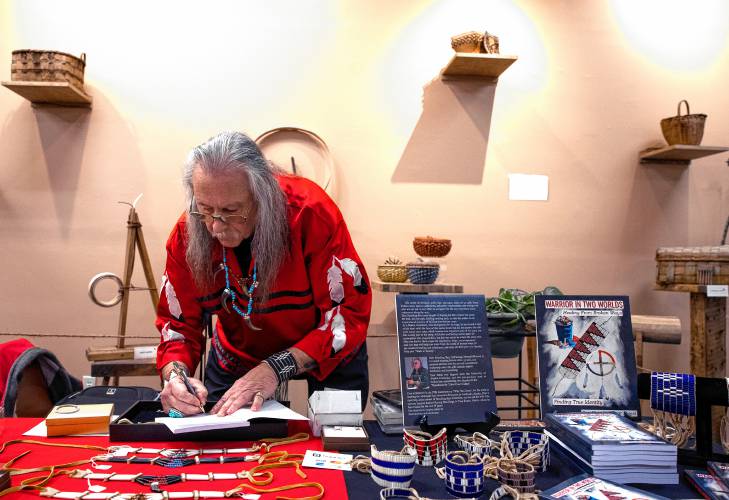 Don Standing Bear Forest signs his book, 
