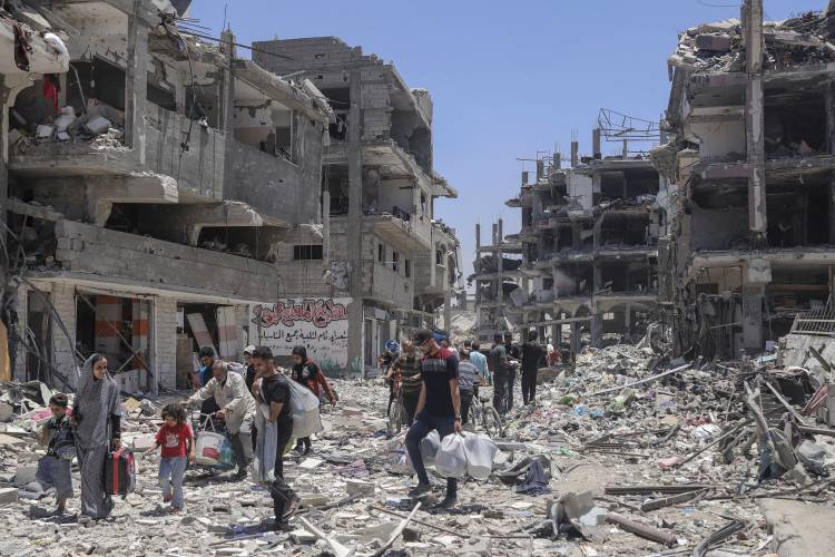 FILE - Palestinians walk through the destruction in the wake of an Israeli air and ground offensive in Jebaliya, northern Gaza Strip, on May 30, 2024. (AP Photo/Enas Rami, File) FILE - Palestinians walk through the destruction in the wake of an Israeli air and ground offensive in Jebaliya, northern Gaza Strip, on May 30, 2024. (AP Photo/Enas Rami, File)