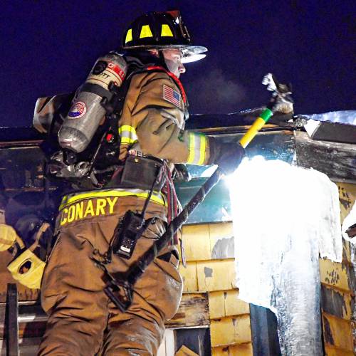 Concord firefighter works on the roof of Granite Ledges after a fire hit the facility on Friday night, February 14, 2025. The two-alarm fire forced residents out into the streets and then to be evacuated to Concord Hospital across the street.
