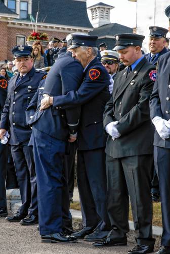 Firefighters hug outside the church before the service for Concord firefighter CJ Girard at Christ the King catholic church in Concord on Thursday, March 13, 2025.