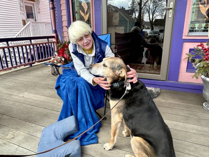 Barbara Filion enjoys a quiet morning on her front porch in Portsmouth with her neighbor's dog Buddy.