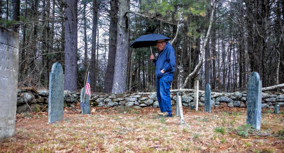 Norm Yeaton looks over a grave marker in the private Yeaton cemetery off of Black Hill Road in Dpsom on Thursday, April 11, 2024. Yeaton has taken on the arduous research project by Yeaton to understand the sheer volume of people in Epsom whose last name was the same as hisâeven when the name was Yeton before they added the ‘a’ sometime in the 19th century.