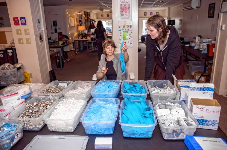 Director of operations for NHHRC Palana Belken shows volunteer Kat Legler how to pack the kits to stock the van.