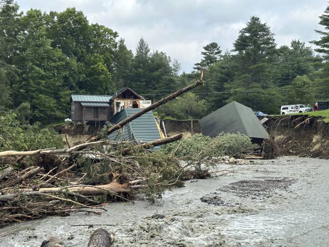 Trees and debris sit next to a damaged home after flooding in Lyndonville, Vt., Tuesday, July 30, 2024. (AP Photo/Nick Perry)