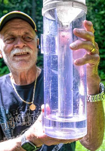 Jim Hilt of Bow holds his rain gauge that overflowed into the outer container after last Thursday's 2.11 inches of rain. The inner tube holds an inch of water and then overflows into the outer portion.
