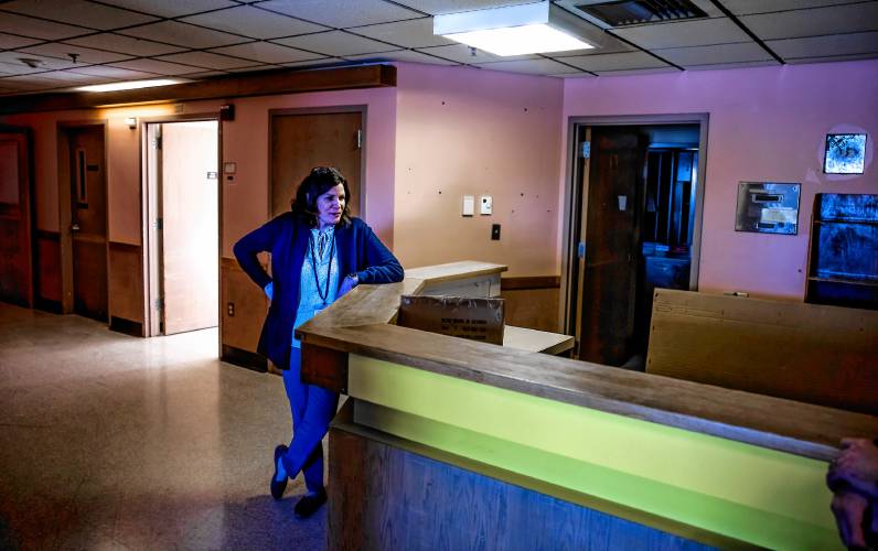 Merrimack County Nursing Home administrator Heather Moquin stands at the nursing station of unrenovated portion of the McLeod Building at the Merrimack County Nursing Home on Monday, March 3, 2025. Moquin started as an LNA at that unit.