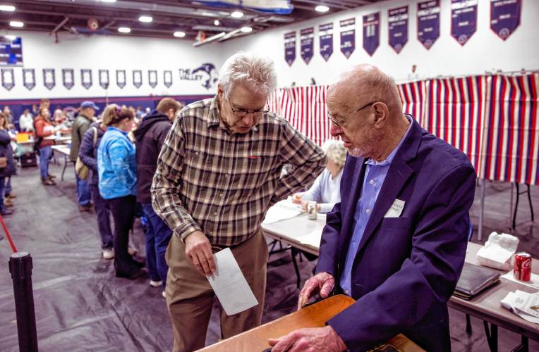 Jeff Blanchard casts his vote as assistant moderator John Herbert stands at the voting box during the Merrimack Valley School District meeting on Thursday night. Herbert was a long time Salisbury town moderator and this will be his last year moderating.