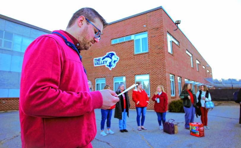 Merrimack Valley High School history teacher Rob Montgomery looks over his notes before he spoke outside the school on Wednesday morning as the school buses arrived and school was about to begin.