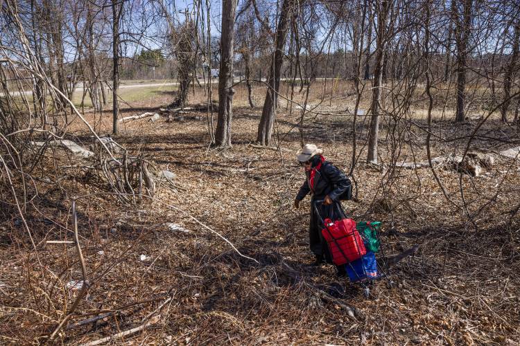 Deborah Eckland walks to the site off off of I-293 where her brother, Glen, was found dead in Manchester.