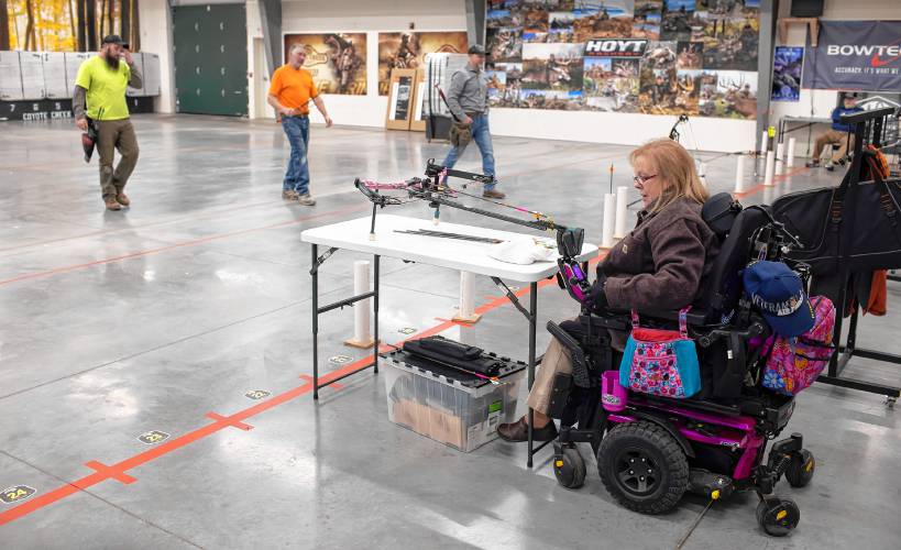 Melinda Simms gets ready to shoot with her custom bow at Coyote Creek Archery in Rochester on Thursday, February 1, 2024.