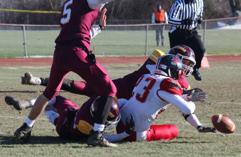 Lebanon's Jon Willeman (5), C.J. Childs, bottom, and Caleb Smith, rear, combine to force a first-quarter fumble from Hillsboro-Deering/Hopkinton's Tyler Allen (23) during their NHIAA Division III football semifinal in Lebanon, N.H., on Saturday, Nov. 16, 2019. Willeman scooped up the turnover and returned it 34 yards for the Raiders' opening touchdown. (Valley News — Greg Fenell) Copyright Valley News. May not be reprinted or used online without permission. Send requests to permission@vnews.com.