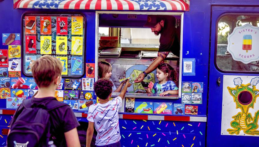 Adam Gelserve serves up ice cream from their van in the neighborhood near where they live in Allenstown on Thursday evening, August 22, 2024. Their girls, Maisie (left), and Avery were there to help as well.