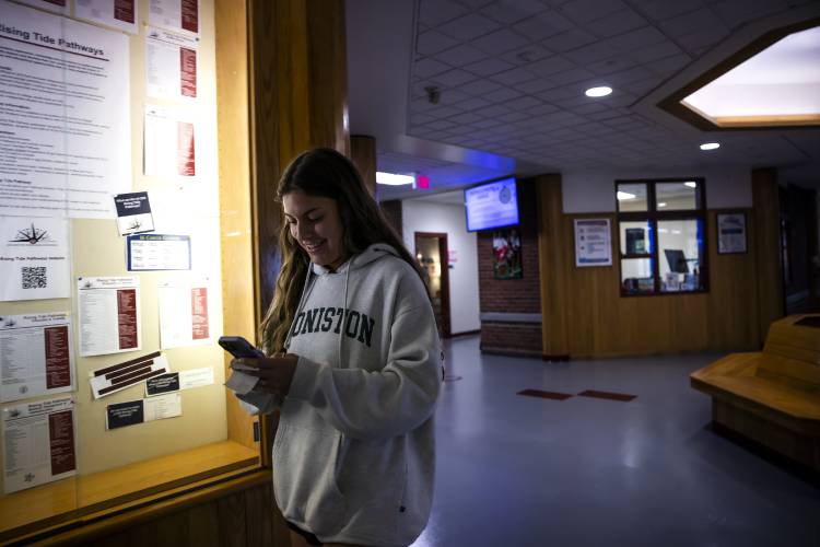 Concord High student Georgia Nolan checks her cell phone as she walks the halls of the school as she travels to class Thursday.