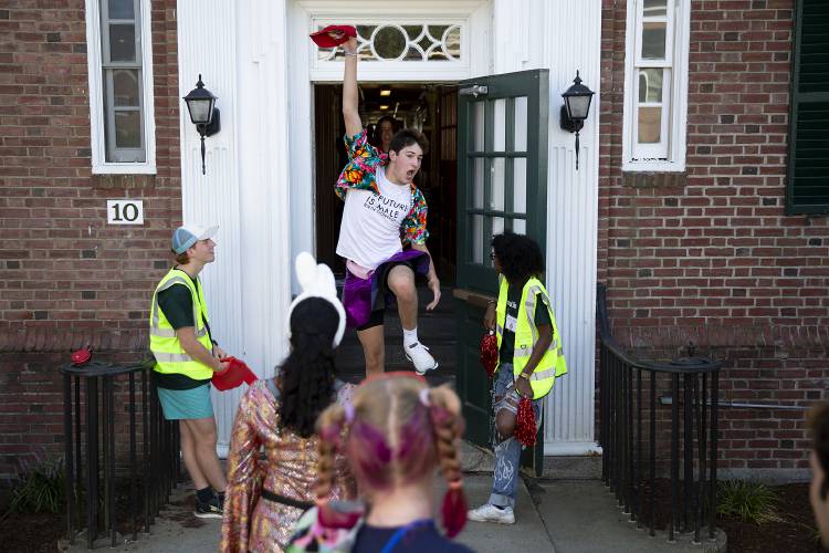 Christian Iturri, center, leaps down the stairs past undergraduate advisors Jonas Thieme, left, and Sydney Mann, right, as they welcome new students during move in at Dartmouth College in Hanover on Sept. 4. Iturri is a member of “H-Croo,” a team of students who provide Hanover-based logistics assistance for the First-Year Trips program, and was on campus welcoming trip participants.