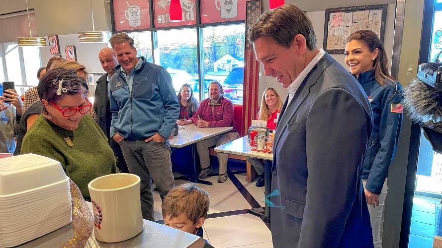 New Hampshire Gov. Chris Sununu campaigned with Florida Gov. Ron DeSantis Tuesday at the Red Arrow Diner in Londonderry. DeSantis was accompanied by his son Mason, foreground, and wife Casey, at right.