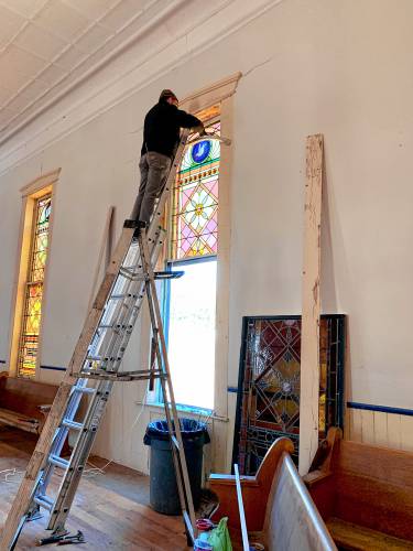 LEFT: Workers repair and install the stained glass windows at the Epsom Old Meetinghouse.