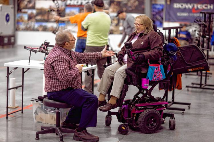 Melinda Simms talks with husband, Rodney, as she gets ready to shoot with her custom bow at Coyote Creek Archery in Rochester on Thursday, February 1, 2024.