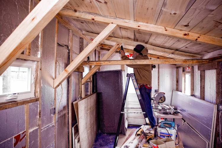 Woodworker David Emerson drills to attach support beams of the tiny house he is modifing on his Canterbury property on Tuesday, March 12, 2024.