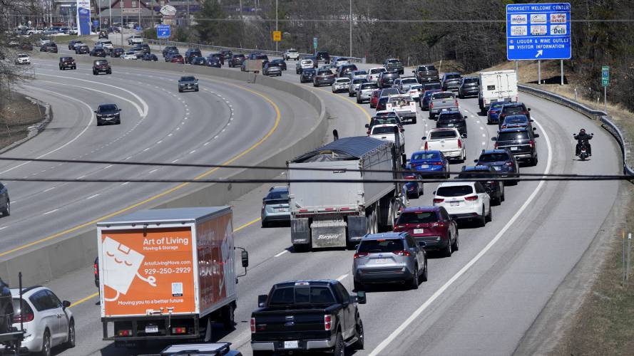 A motorcycle cruises down the breakdown lane as solar eclipse seekers and drivers head north on Route 93 in heavy traffic hours before an afternoon total eclipse, Monday, April 8, 2024, in Hooksett, N.H. (AP Photo/Charles Krupa)