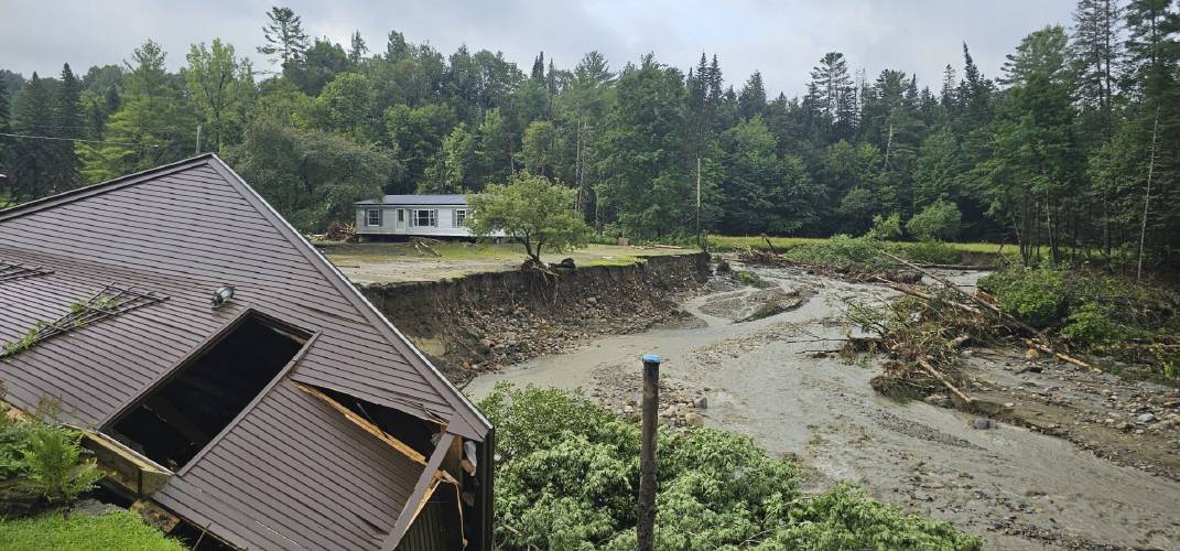 In this photo provided by the Lyndonville Fire Department, damaged homes sit alongside a river in Lyndonville, Vt., after flash floods hit the area, Tuesday, July 30, 2024. (Lyndonville Fire Chief Jeff Carrow via AP)