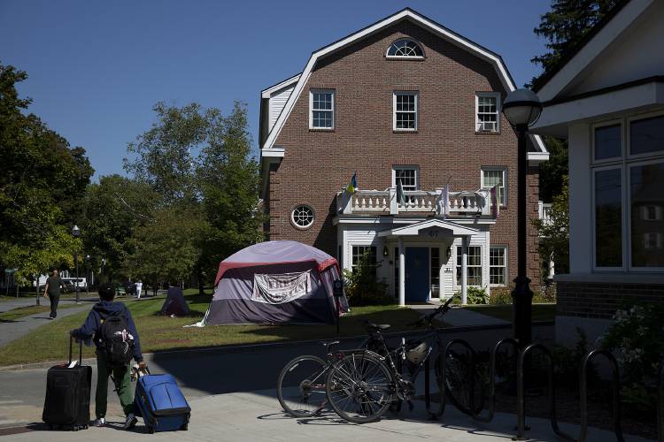A tent adorned with “Free Palestine” and “Drop the Charges” signs is pitched on the lawn of Phi Tau, a gender-inclusive greek society, during Dartmouth’s move in. Tensions between student activists and the college administration remain high as cases against protesters arrested while demonstrating on campus wend their way through court.