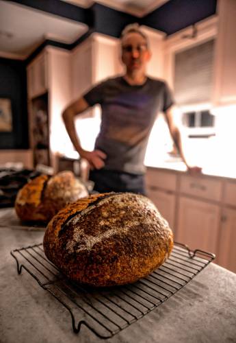 Alex Brown with his signature bread he makes at his South End home. Brown is getting a new bread oven to increase his weekly output.